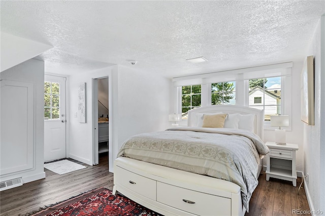 bedroom with dark wood-type flooring and a textured ceiling