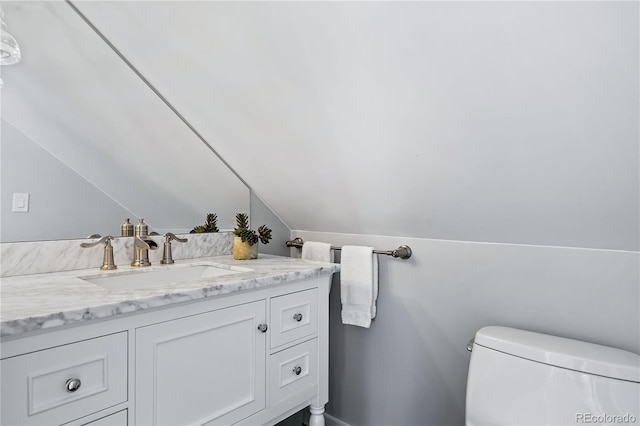 bathroom featuring lofted ceiling, vanity, and toilet