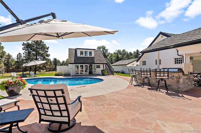 view of pool with a patio, an outbuilding, and an outdoor bar