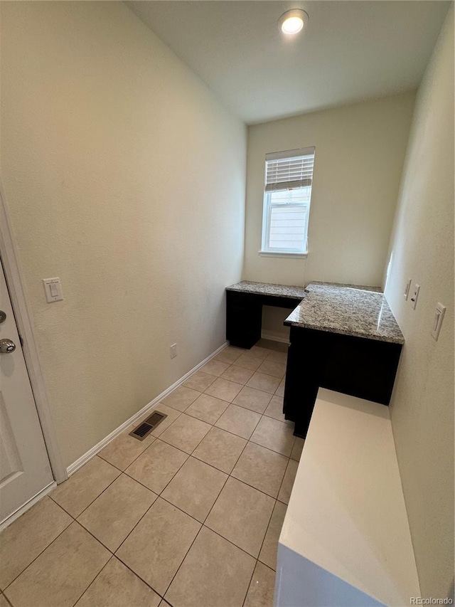 interior space with built in desk and light tile patterned floors