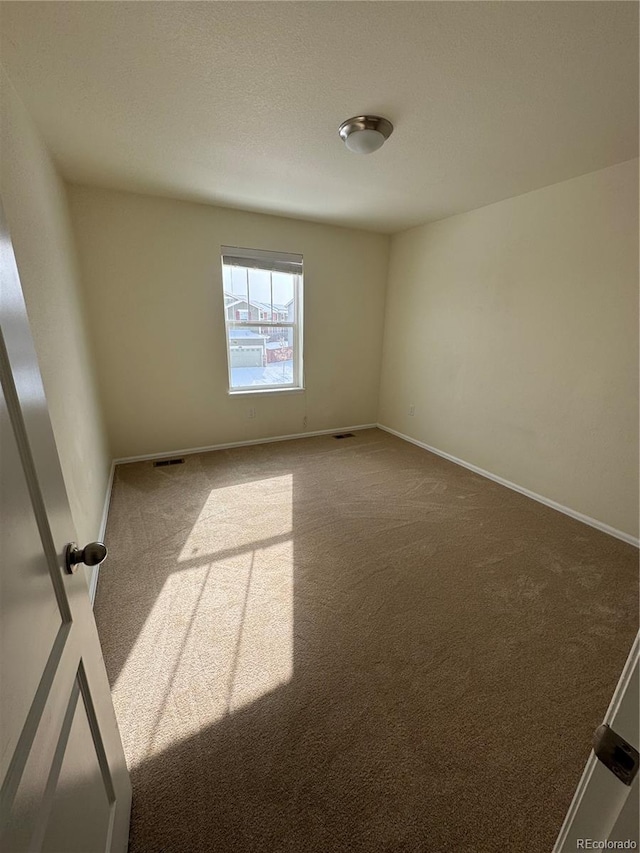 unfurnished room with a textured ceiling and carpet flooring