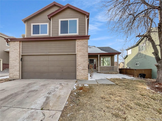 traditional-style house with driveway, brick siding, an attached garage, and fence