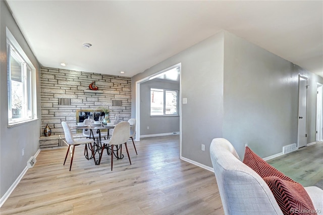 2921 E Colorado Ave, Denver, CO 80210 - dining room featuring light wood-style flooring, a fireplace, visible vents, and baseboards
