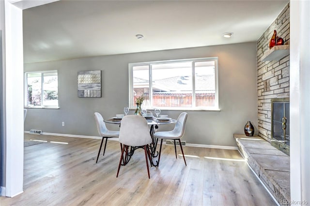 2921 E Colorado Ave, Denver, CO 80210 - dining space featuring visible vents, a stone fireplace, and wood finished floors