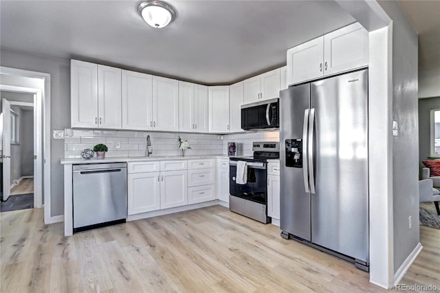 2921 E Colorado Ave, Denver, CO 80210 - kitchen with light countertops, backsplash, appliances with stainless steel finishes, white cabinets, and a sink