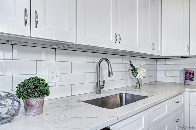 2921 E Colorado Ave, Denver, CO 80210 - kitchen with tasteful backsplash, white cabinets, and a sink