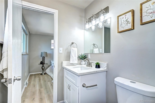 2921 E Colorado Ave, Denver, CO 80210 - bathroom featuring toilet, baseboards, wood finished floors, and vanity