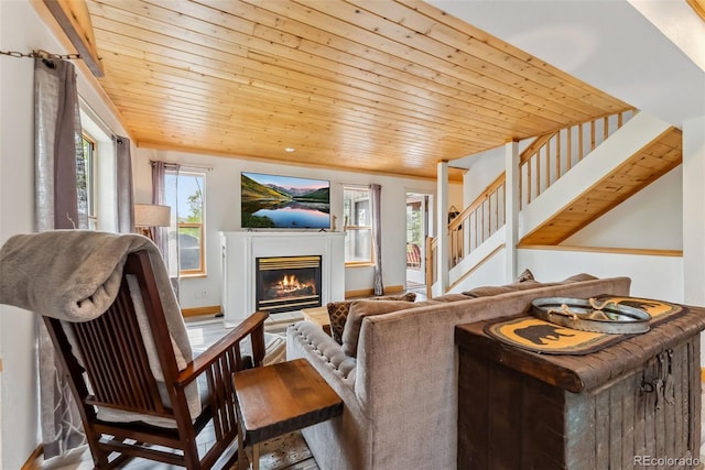 2028 Redhill Rd, Fairplay, CO 80440 - living area featuring a glass covered fireplace, stairs, wood ceiling, and baseboards