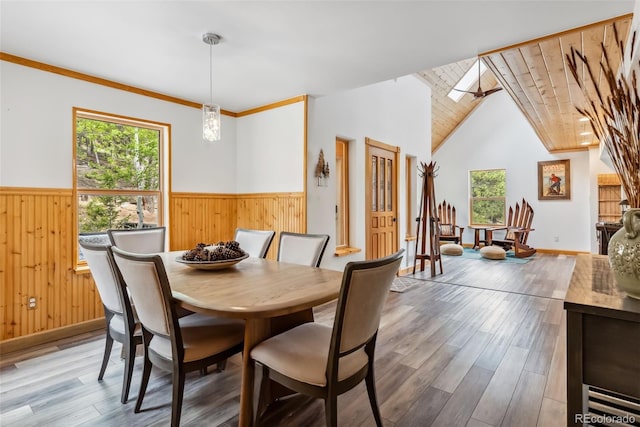 2028 Redhill Rd, Fairplay, CO 80440 - dining space featuring healthy amount of natural light, wooden walls, wainscoting, wood finished floors, and vaulted ceiling