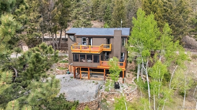 2028 Redhill Rd, Fairplay, CO 80440 - rear view of property featuring a sunroom, a balcony, a forest view, and a wooden deck