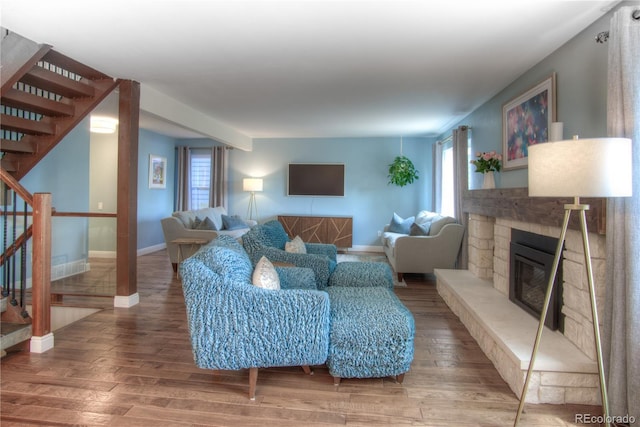 8140 S Storm King Peak, Littleton, CO 80127 - living room with a stone fireplace, stairway, and wood finished floors