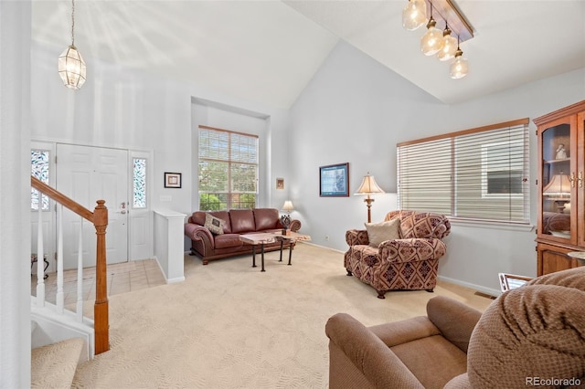 living room with high vaulted ceiling, light carpet, and stairs
