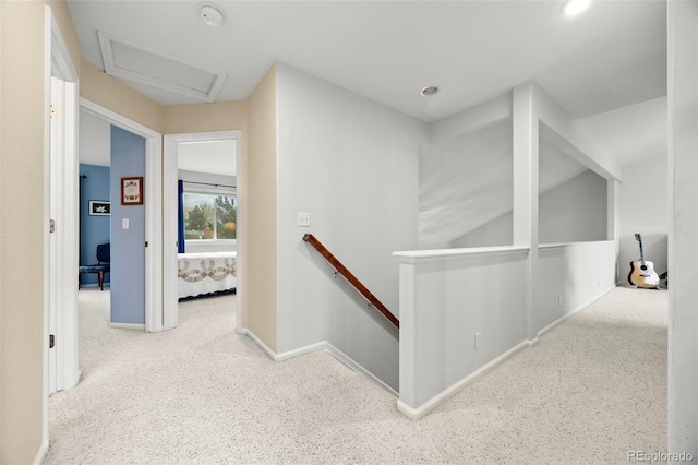 corridor with an upstairs landing, attic access, carpet floors, baseboards, and recessed lighting