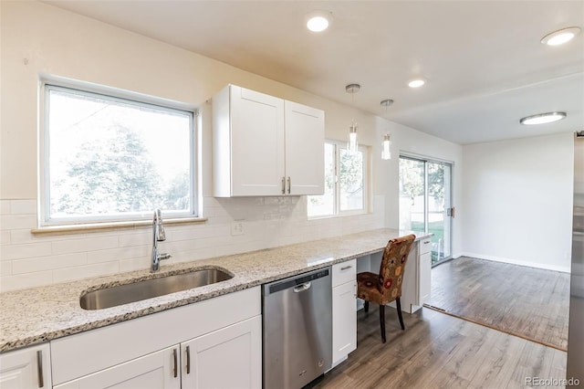 kitchen featuring backsplash, dishwasher, a sink, white cabinets, and light wood-style floors