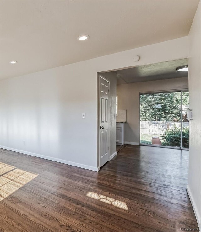 empty room featuring baseboards, recessed lighting, and wood finished floors