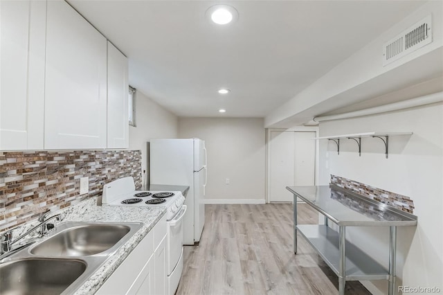 kitchen featuring visible vents, decorative backsplash, white appliances, white cabinets, and a sink