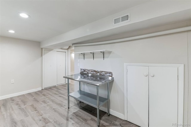 finished below grade area with visible vents, recessed lighting, light wood-style flooring, and baseboards