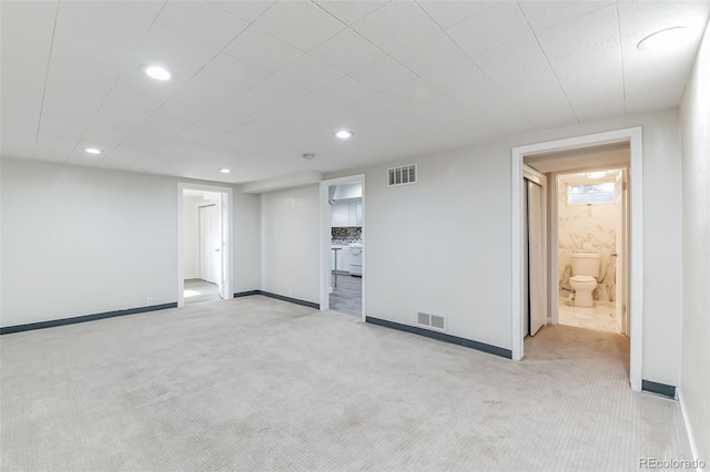 unfurnished living room featuring visible vents, baseboards, and light carpet