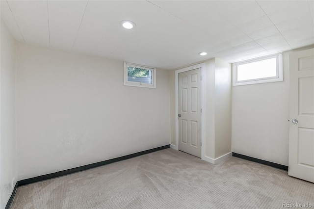 basement featuring a healthy amount of sunlight, light carpet, and recessed lighting