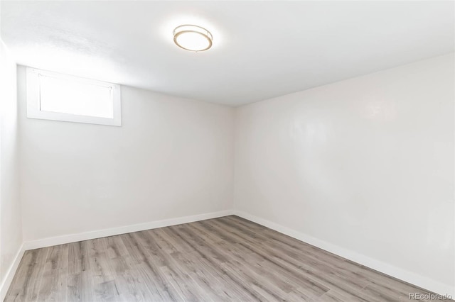 basement featuring baseboards and light wood-style flooring