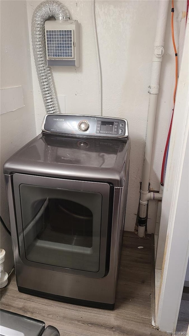 clothes washing area featuring washer / dryer, laundry area, and wood finished floors
