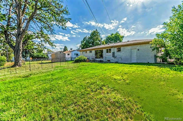 back of house with a lawn and fence