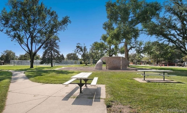 view of community featuring a lawn and fence