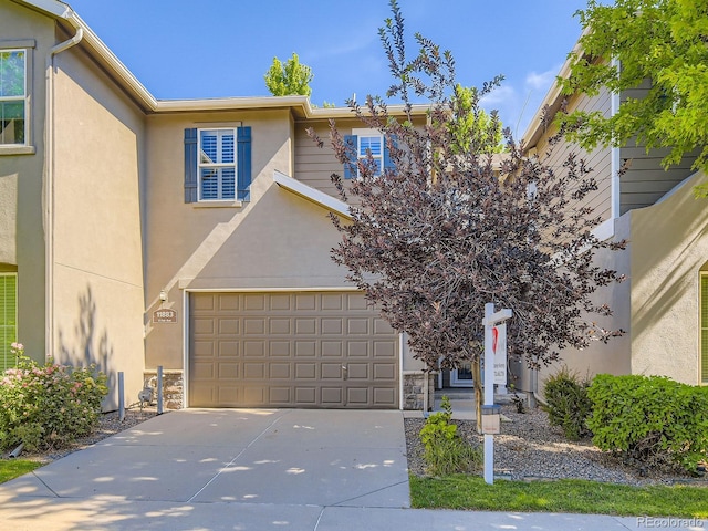 11883 E Fair Ave, Greenwood Village, CO 80111 - view of front of house featuring concrete driveway and stucco siding