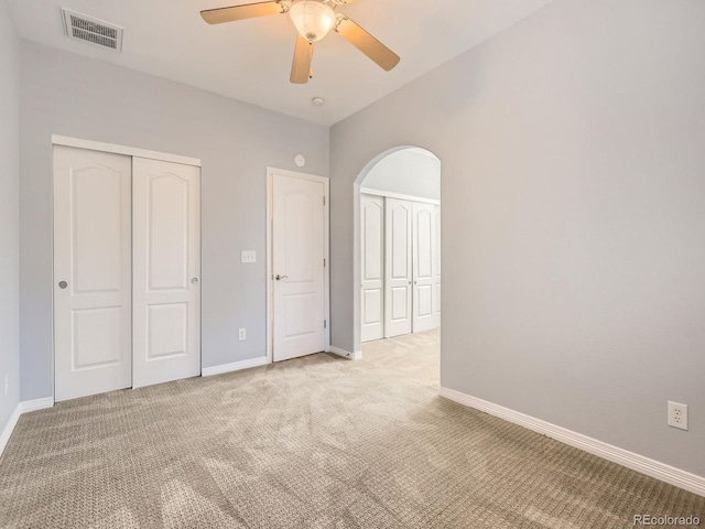 11883 E Fair Ave, Greenwood Village, CO 80111 - unfurnished bedroom featuring light colored carpet, arched walkways, and ceiling fan