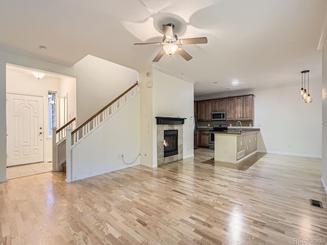 11883 E Fair Ave, Greenwood Village, CO 80111 - unfurnished living room featuring ceiling fan, light wood-style floors, a premium fireplace, stairway, and crown molding