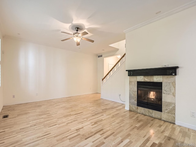 11883 E Fair Ave, Greenwood Village, CO 80111 - unfurnished living room with wood finished floors, a tiled fireplace, ceiling fan, and stairs