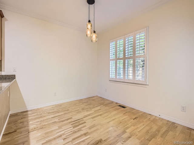 11883 E Fair Ave, Greenwood Village, CO 80111 - unfurnished dining area with light wood-type flooring and crown molding