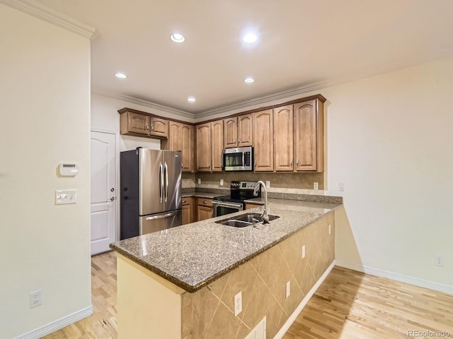 11883 E Fair Ave, Greenwood Village, CO 80111 - kitchen with appliances with stainless steel finishes, a peninsula, ornamental molding, backsplash, and dark stone counters