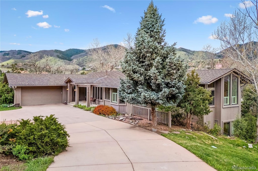 6093 Willowbrook Dr, Morrison, CO 80465 - view of front facade featuring a garage, a mountain view, driveway, and fence