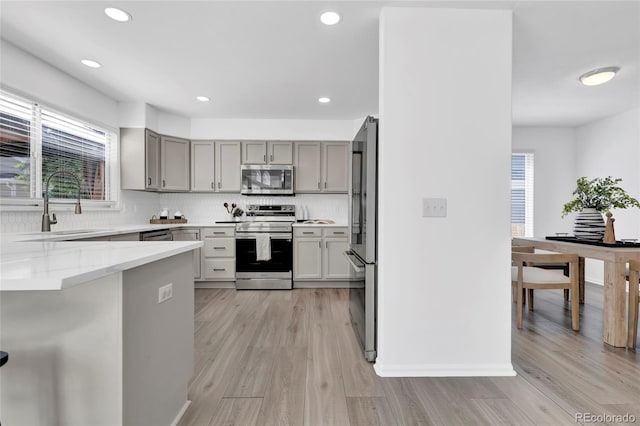 275 S Pembrook St, Castle Rock, CO 80104 - kitchen with appliances with stainless steel finishes, gray cabinets, healthy amount of natural light, light wood-style flooring, and recessed lighting