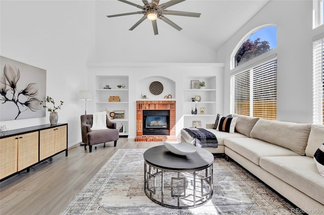 275 S Pembrook St, Castle Rock, CO 80104 - living area featuring high vaulted ceiling, built in shelves, a fireplace, light wood finished floors, and a ceiling fan