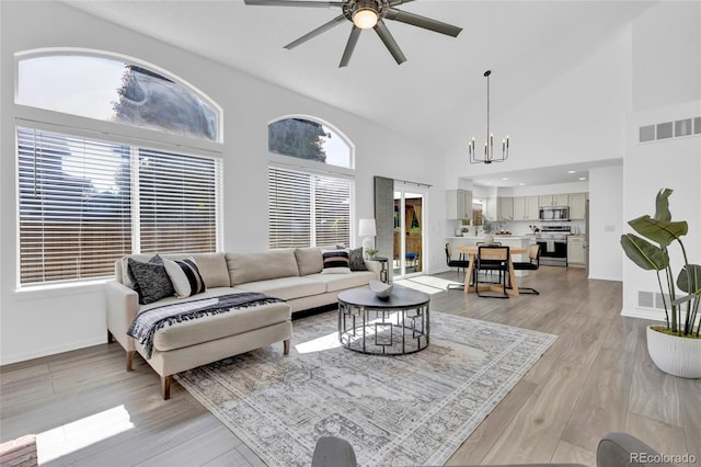 275 S Pembrook St, Castle Rock, CO 80104 - living area with a ceiling fan, light wood-style flooring, a chandelier, high vaulted ceiling, and baseboards