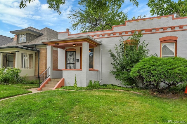 1005 S Pennsylvania St, Denver, CO 80209 - view of front of home with a front yard, entry steps, roof with shingles, and brick siding