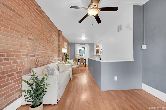 1005 S Pennsylvania St, Denver, CO 80209 - living area with light wood-type flooring, a ceiling fan, and brick wall