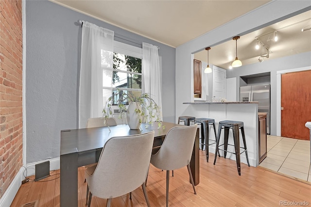 1005 S Pennsylvania St, Denver, CO 80209 - dining room with brick wall and light wood finished floors