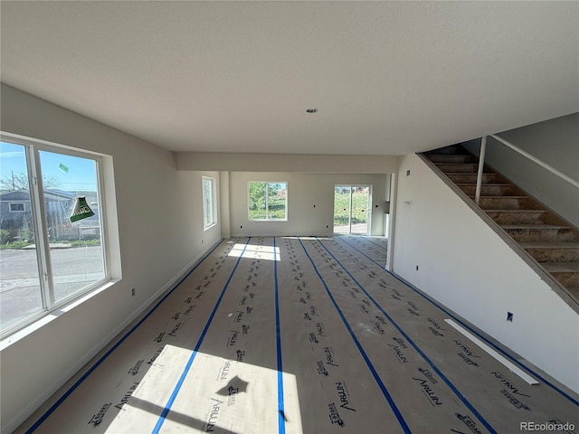 701 Little Bear, Colorado Springs, CO 80907 - unfurnished living room featuring stairway and baseboards