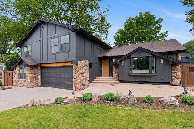 4269 Carter Trl, Boulder, CO 80301 - view of front of house with board and batten siding, stone siding, an attached garage, and driveway