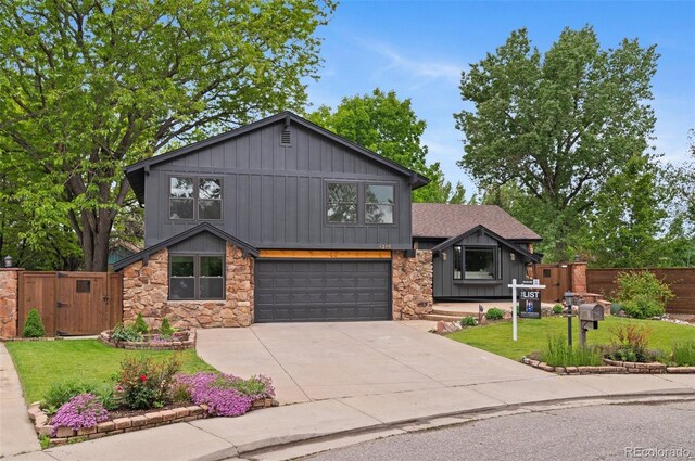 4269 Carter Trl, Boulder, CO 80301 - view of front facade with stone siding, board and batten siding, a garage, a gate, and driveway
