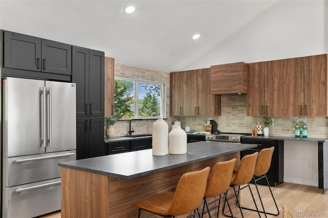 4269 Carter Trl, Boulder, CO 80301 - kitchen with appliances with stainless steel finishes, a sink, vaulted ceiling, a kitchen breakfast bar, and tasteful backsplash