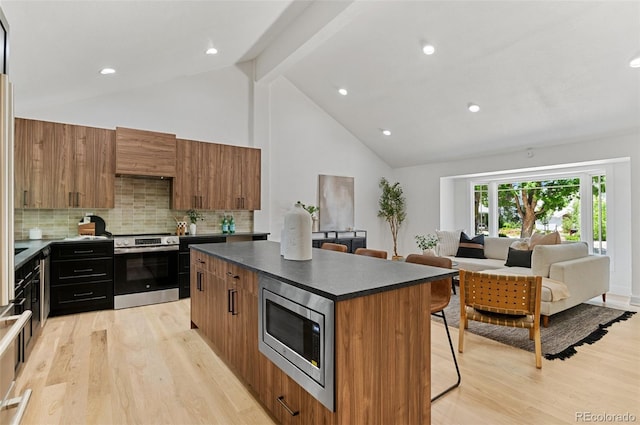 4269 Carter Trl, Boulder, CO 80301 - kitchen with appliances with stainless steel finishes, a kitchen island, a kitchen bar, light wood-style flooring, and beamed ceiling