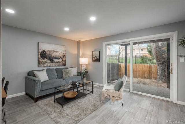 living area with recessed lighting, baseboards, and wood finished floors