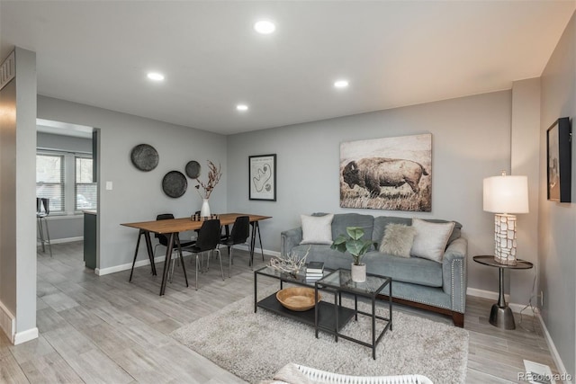 living room with recessed lighting, light wood-style flooring, and baseboards