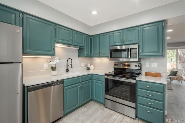 kitchen featuring a sink, light countertops, appliances with stainless steel finishes, wood tiled floor, and recessed lighting