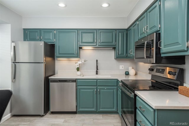 kitchen with stainless steel appliances, recessed lighting, light countertops, and a sink