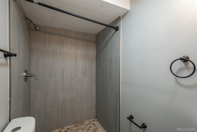 full bathroom featuring toilet and tiled shower
